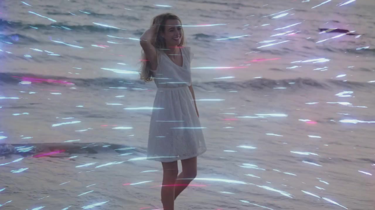 Mulher sorrindo e dando um passo à frente, andando na areia molhada enquanto raios de luz se sobrepõem para moda