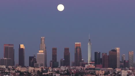 telephoto dolly aerial shot of downtown los angeles at sunset under a full moon in southern california. 4k