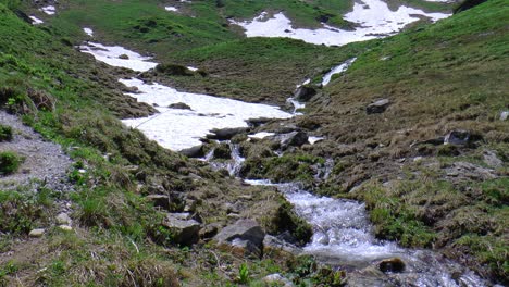 waterfall in a valley flows under the snow
