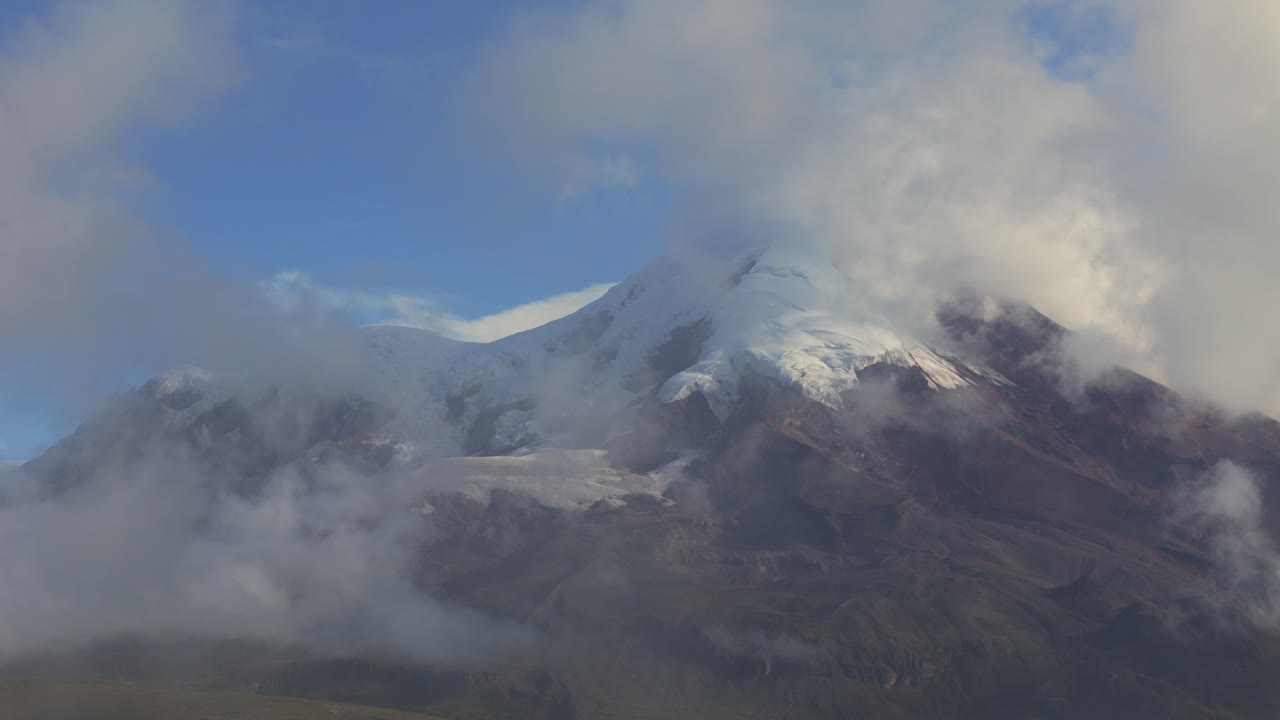visión general del volcán chimborazo en ecuador con nubes circundantes y terreno accidentado, nubes de niebla oscurecen las rocas