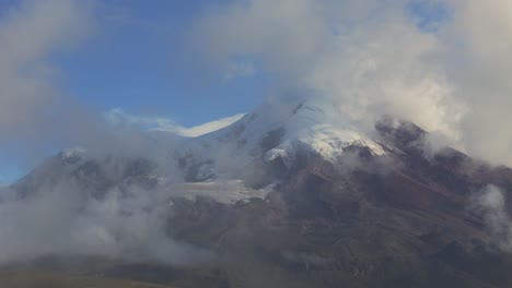 visión general del volcán chimborazo en ecuador con nubes circundantes y terreno accidentado, nubes de niebla oscurecen las rocas