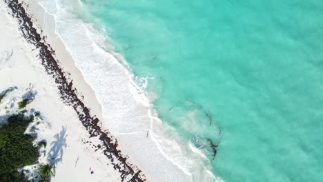 Aérea-Flotando-Sobre-Las-Fascinantes-Aguas-Azul-Turquesa-De-Isla-Blanca,-México,-La-Vista-Aérea-Revela-Una-Escena-Pintoresca-Donde-Las-Olas-Chocan-Suavemente-Contra-La-Prístina-Playa-De-Arena-Blanca.