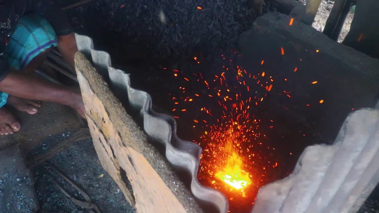 방글라데시 다카에서 전통 대장장이가 금속 막대를 가열하여 불꽃 소나기를 만듭니다.