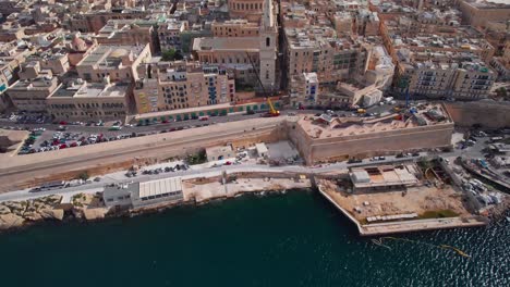 aerial tilt reveal of st paul's cathedral dome in valletta skyline, malta