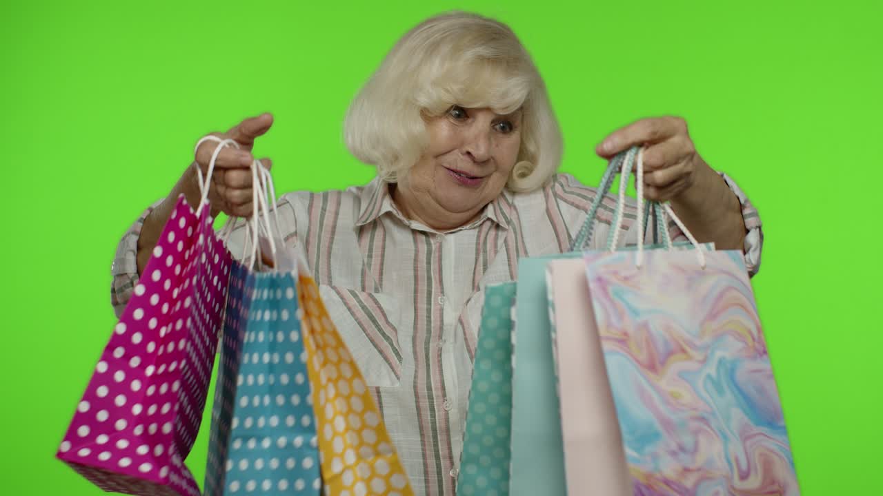 할머니는 쇼핑 가방을 들고 가게에서 할인을 즐기고 저렴한 가격으로 쇼핑을 즐기고 있습니다.