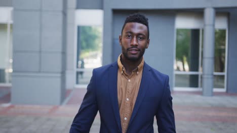 portrait of african american businessman walking in city street