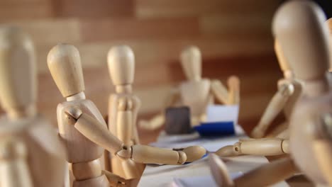 Wooden-figurines-having-meeting-in-conference-room