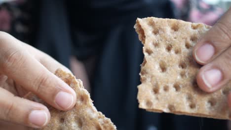 person eating a piece of rye bread