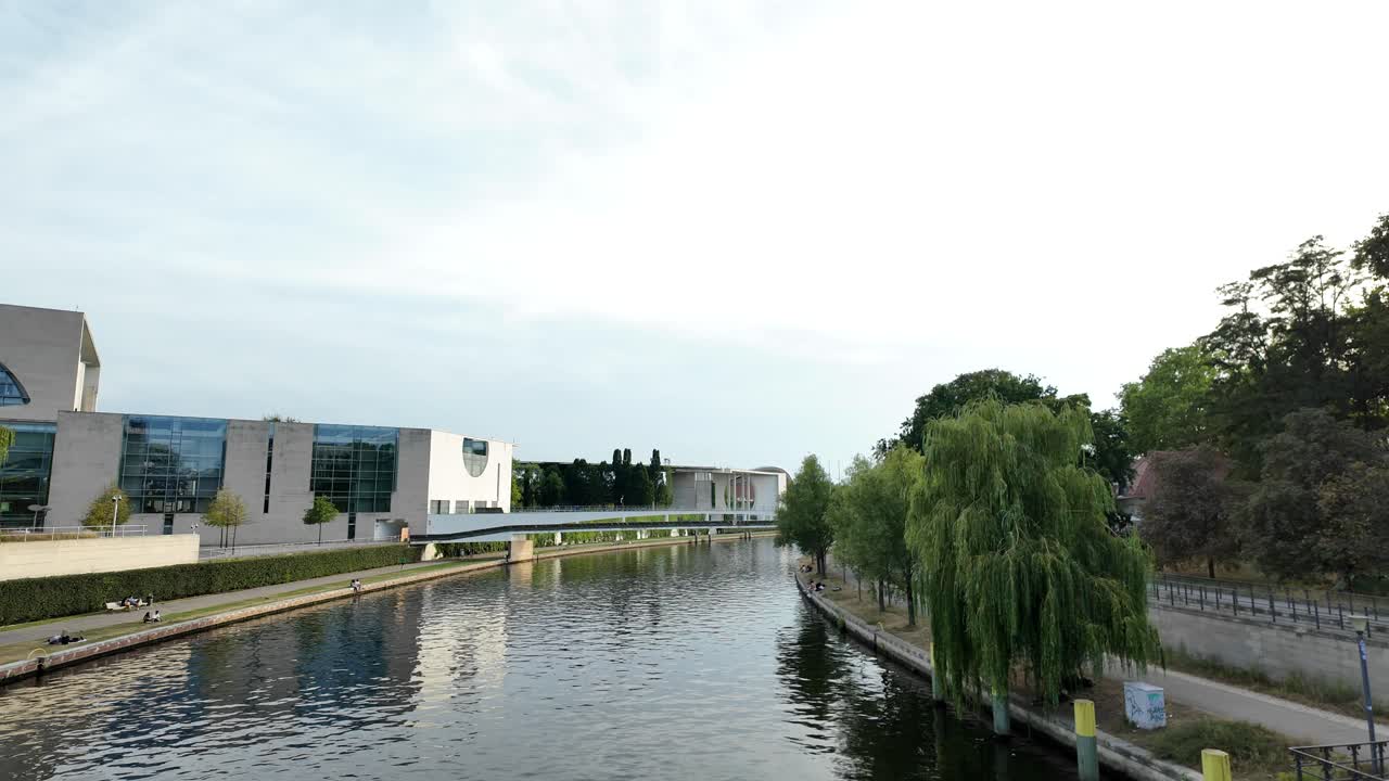 View of the river Spree in Berlin, with the Federal Chancellery in the background on the left side. The calm waters and modern architecture create a peaceful urban scene