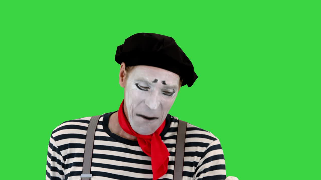 mime gracioso usando un teléfono inteligente imaginario en una pantalla verde, tecla de croma