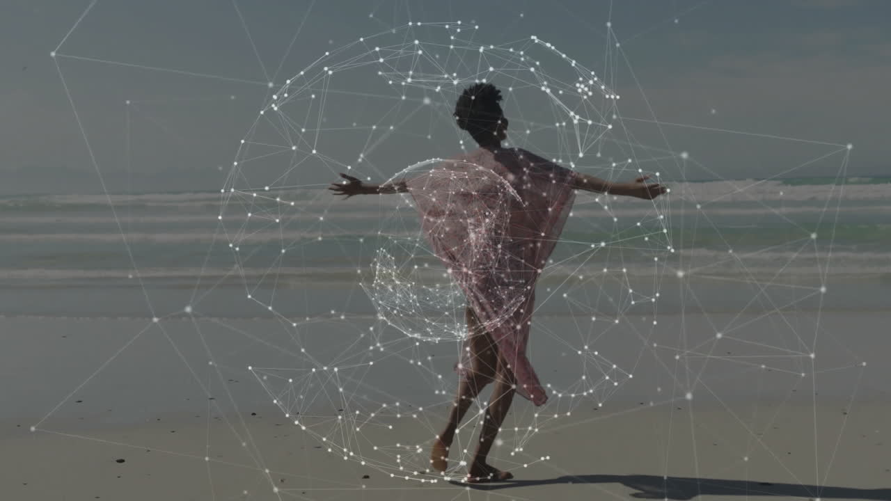 woman walking barefoot along sandy beach, showing technology network overlay forming white spheres