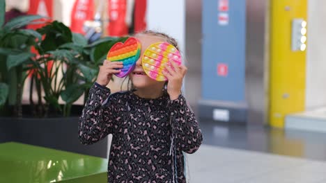 little girl having fun with pop it fidget toys