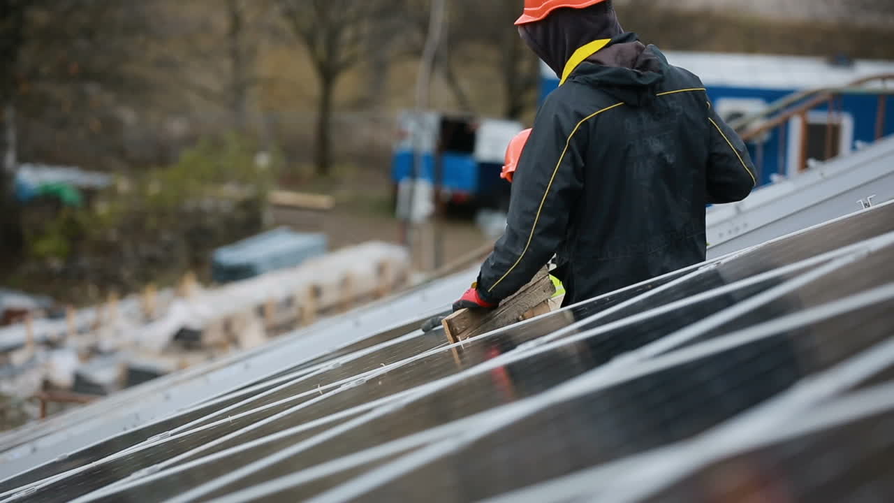 VINNITSA, UKRAINE - NOVEMBER 2017: Solar panel and professional worker installing photovoltaic solar panels