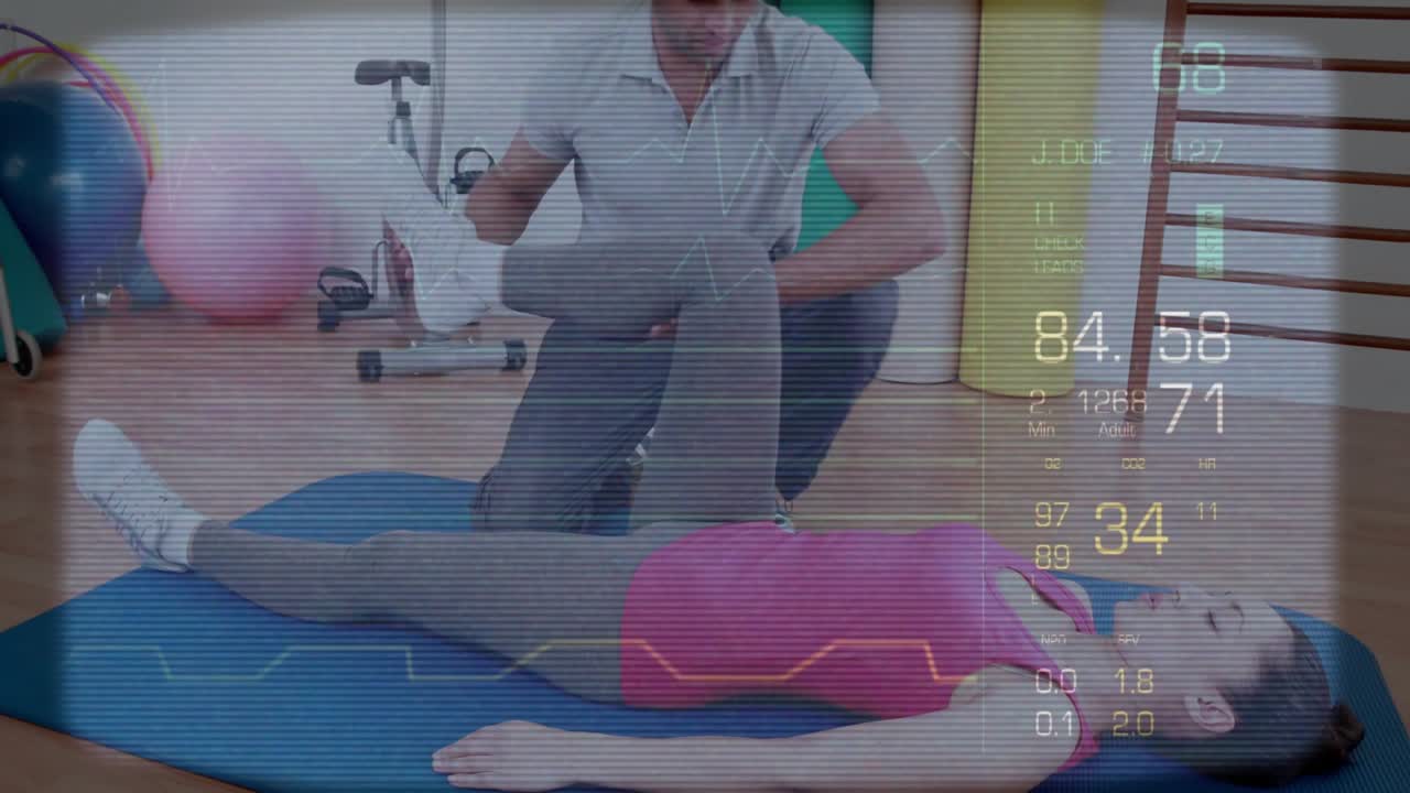 Terapeut kneler ved siden av kvinne på blå matte, løfter høyre ben, veileder passivt bevegelsesutslag med HUD-vitaler