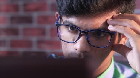 joven estresado mientras trabaja en la computadora portátil