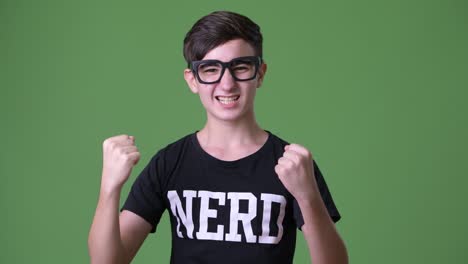 young handsome iranian teenage boy against green background