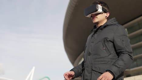 hombre joven usando auriculares vr al aire libre