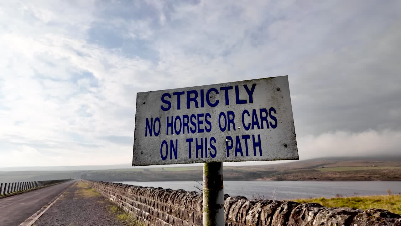 Sign strictly restricting horses and cars on path next to Burnhope Reservoir and dry stone wall