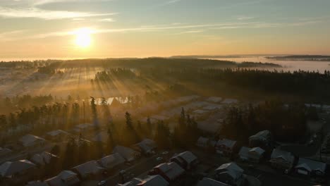 aerial view of an oak harbor neighborhood covered in frost while the sun rays cut through the morning fog