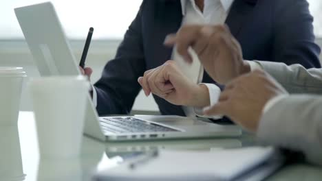 Closeup-shot-of-two-employees-working-with-laptop-in-office