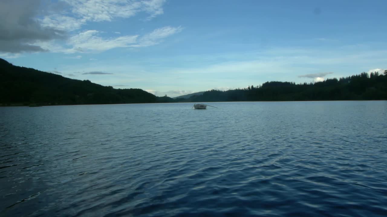 여름 날 스코틀랜드 호수에 빈 나무로 잉 보트