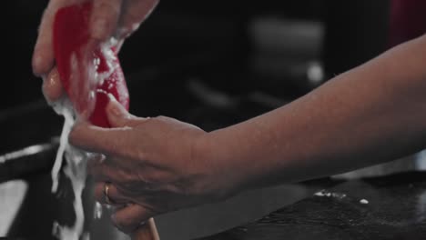 Washing-spatula-in-sink-under-running-water