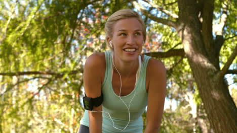 fitte blondine macht eine pause im park