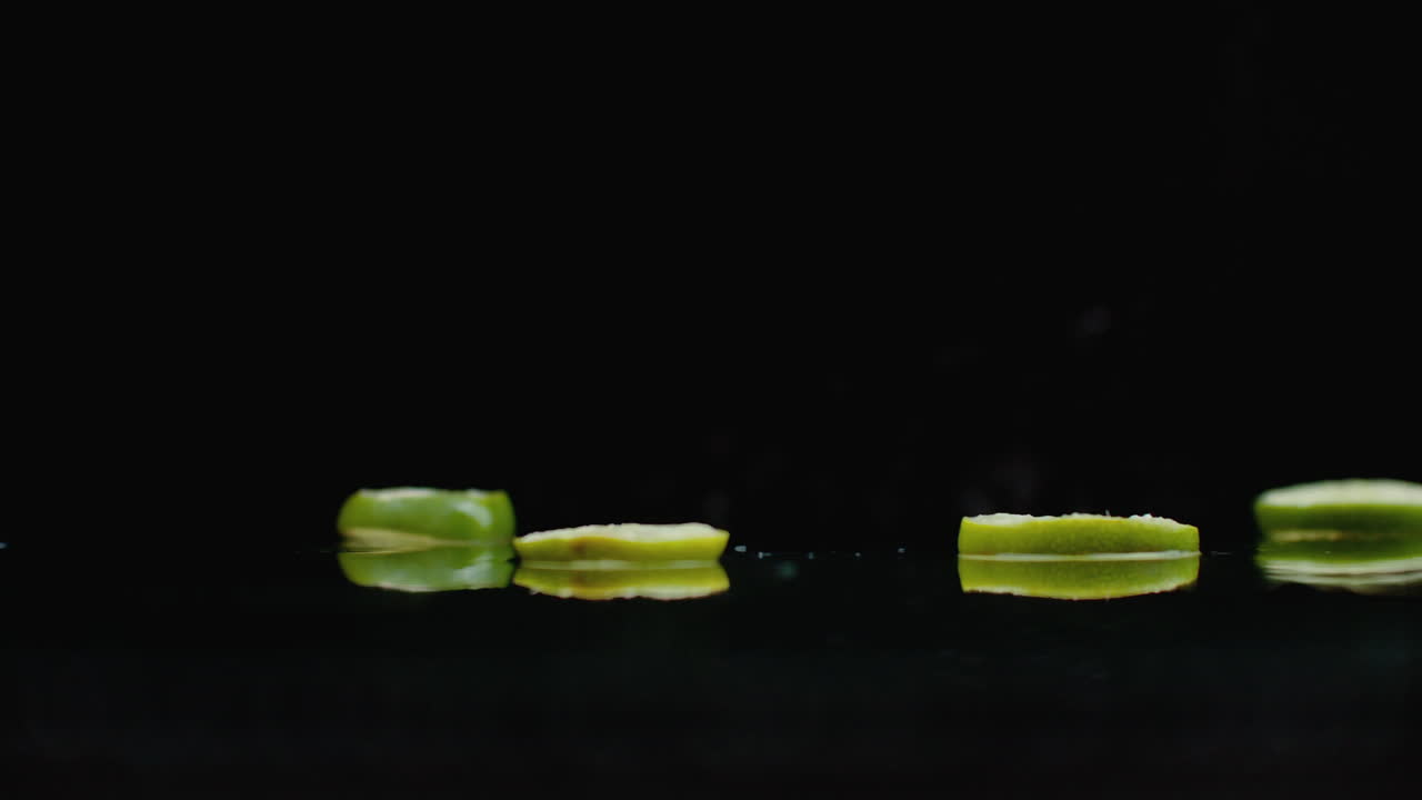 Rings Of Fresh Green Lime Sliced Fall On The Glass With Splashes Of