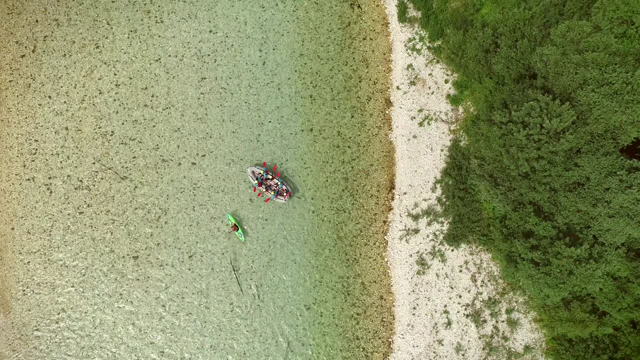 소카 강 (soca river) 의 푸른 물에서 래프팅을 하는 래프터 그룹의 공중 사진.