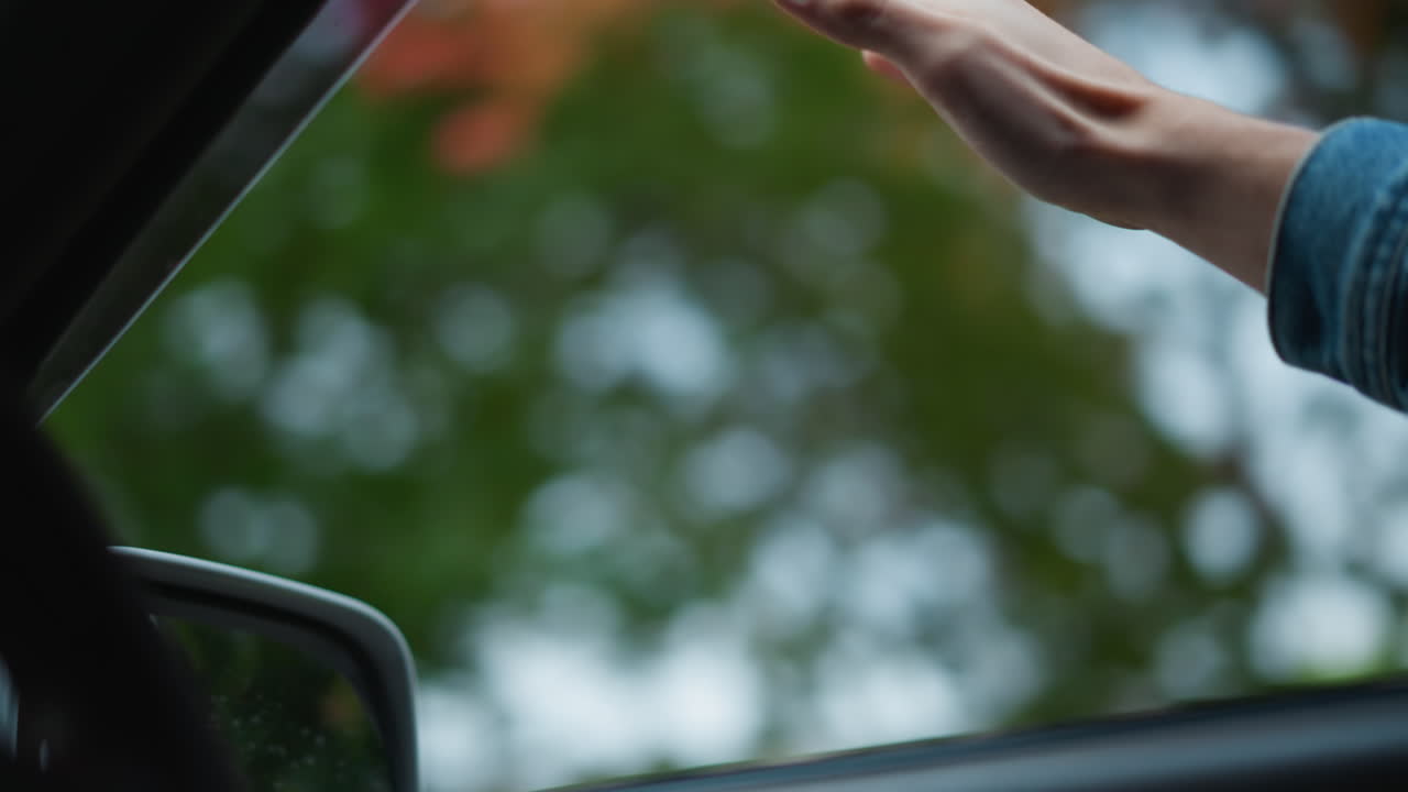 Traffico con un autista che fa dei gesti fuori dal finestrino, pendolare che fa un gesto con la mano mentre guida in una città nuvolosa, autista che segnala qualcosa con la mano in una giornata nuvolosa e in un contesto di traffico urbano intenso