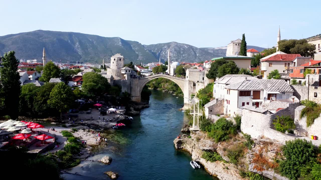 Droneopptak av den gamle broen i Mostar ved soloppgang, Bosnia og Herzegovina. Luftfoto av den historiske steinbroen over elven Neretva, ideell for reise- og turismebruk