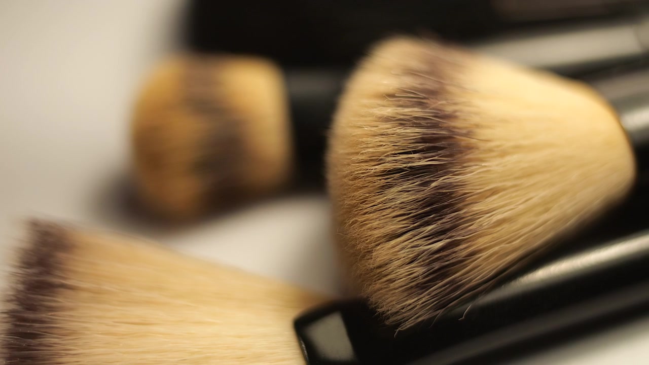 50p extreme close up slider shot moving across white makeup brushes