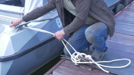 hombre atando un barco en un muelle