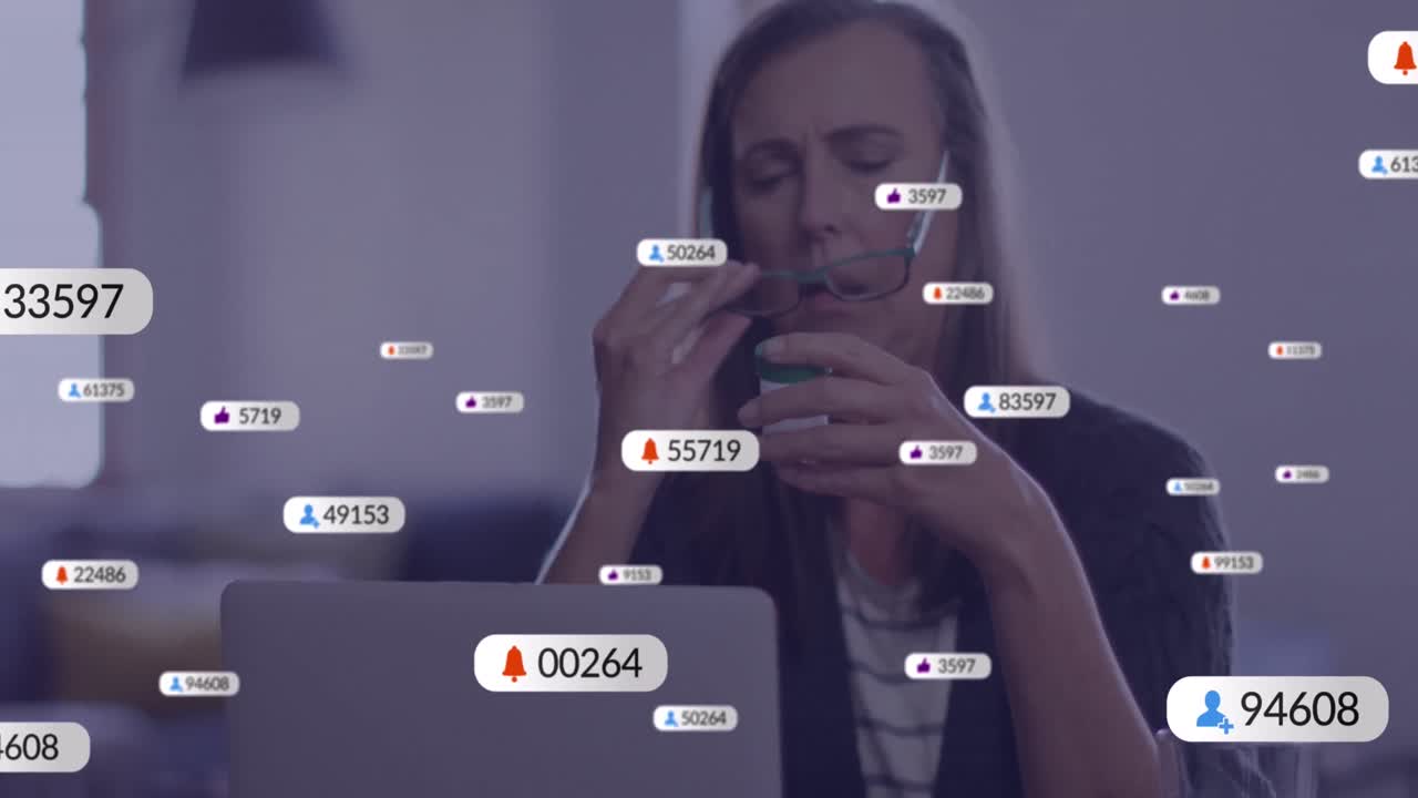 animación de iconos de redes sociales con números sobre una mujer caucásica anciana usando una computadora portátil.