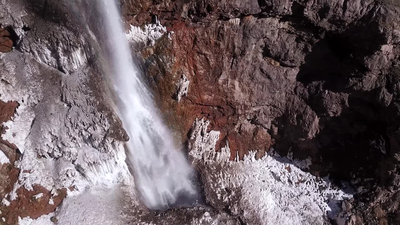 cascada de hielo fluye fuertemente desde un acantilado en un terreno cubierto de nieve en la naturaleza salvaje
