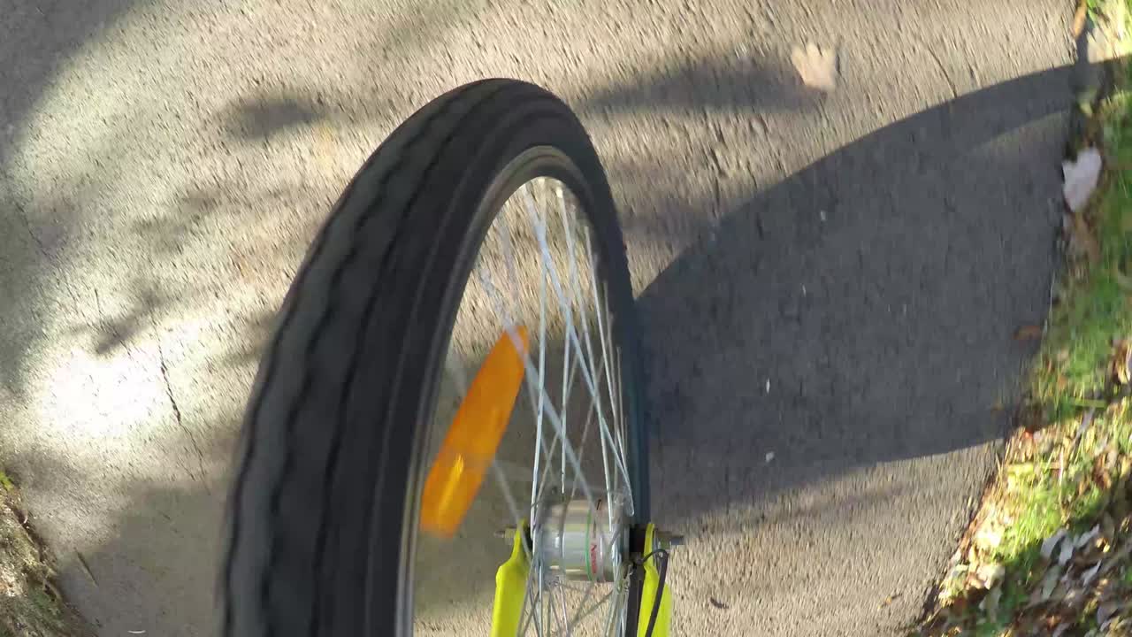 Upper view of the front wheel of the bicycle on the road.