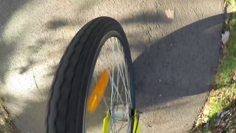 upper view of the front wheel of the bicycle on the road.