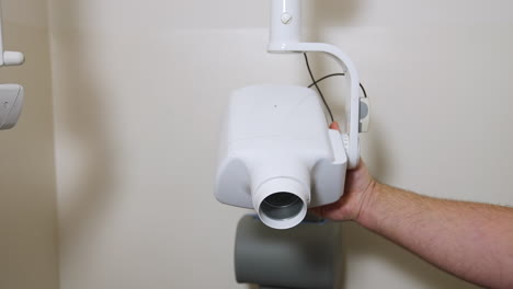 male hand rotates dental x-ray apparatus. dentistry equipment is being prepared for work.