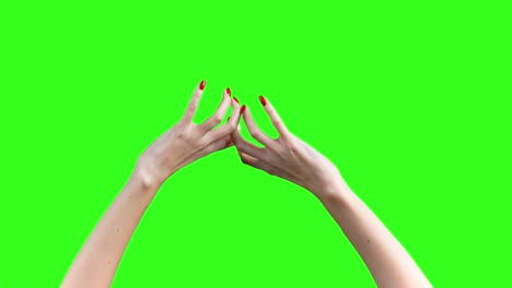 shooting of tearing something female hands on green background