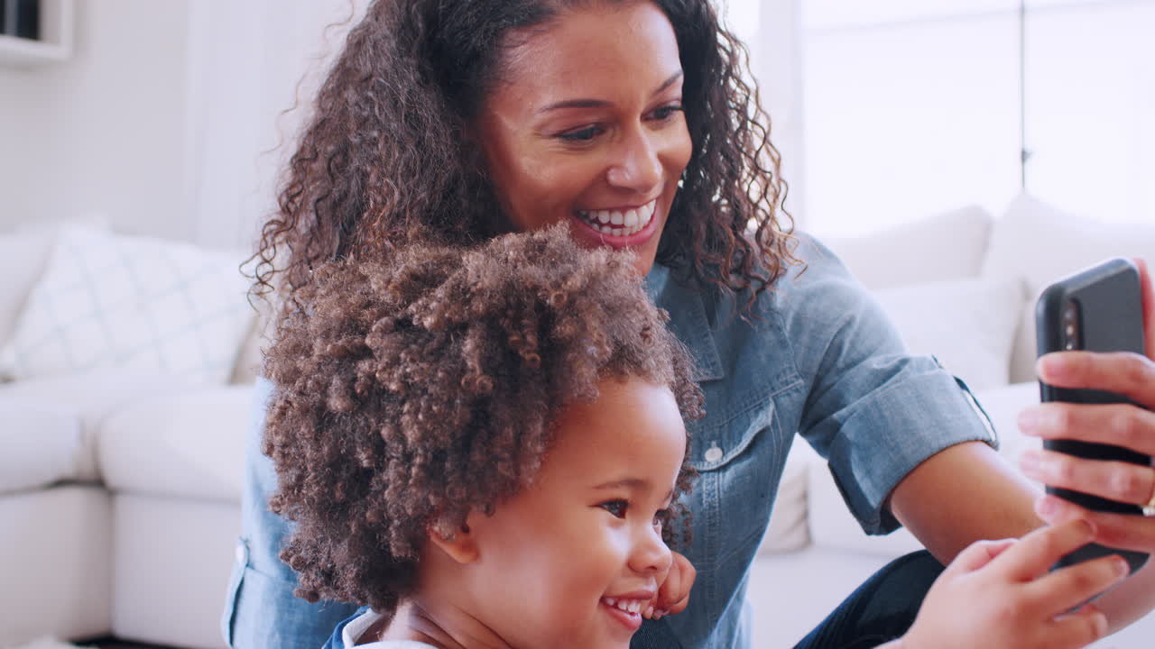 Young black woman and daughter making a face taking selfie