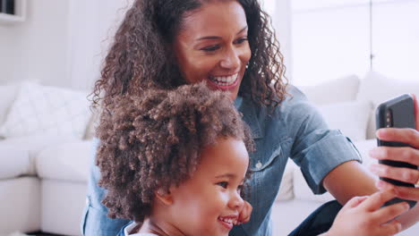 Young-black-woman-and-daughter-making-a-face-taking-selfie