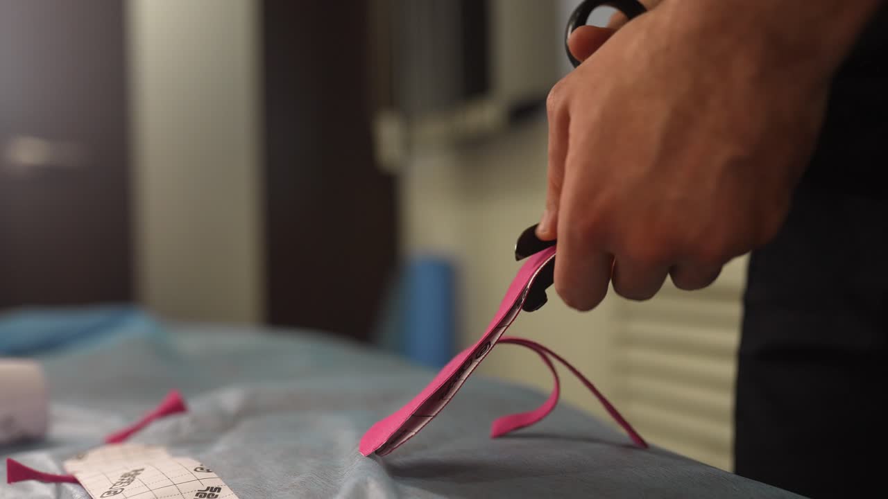 가위와 분홍색 재료를 사용하는 의학적 절차