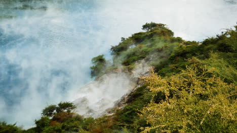 toma de arriba hacia abajo del vapor de azufre tóxico que vuela sobre el lago del cráter del infierno durante la luz del sol - waimangu, nueva zelanda