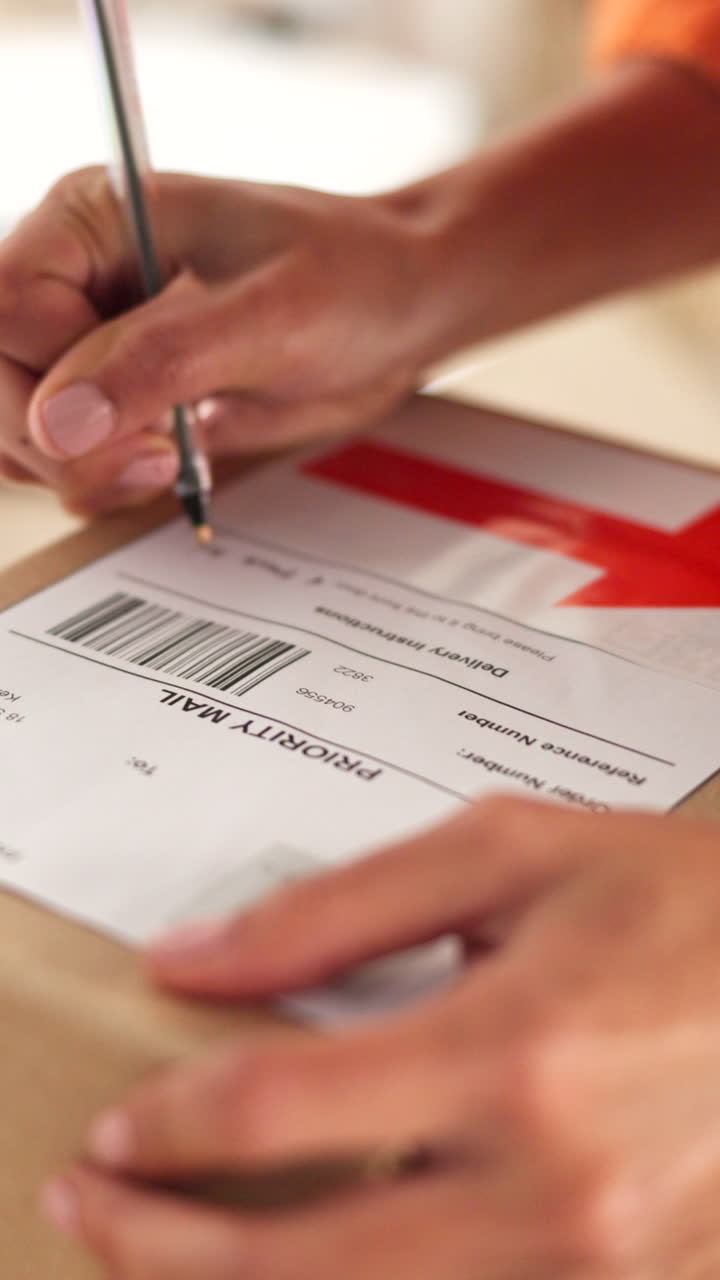 Primo piano di mani che scrivono su un'etichetta di spedizione Priority Mail