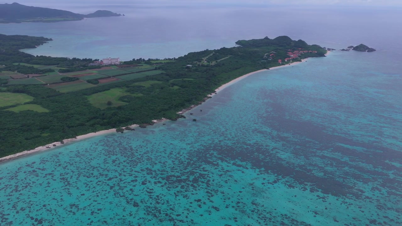 Riprese aeree orizzontali con panoramica a sinistra e movimento laterale a destra lungo la costa vicino al Club Med sull'isola di Ishigaki, Okinawa, Giappone