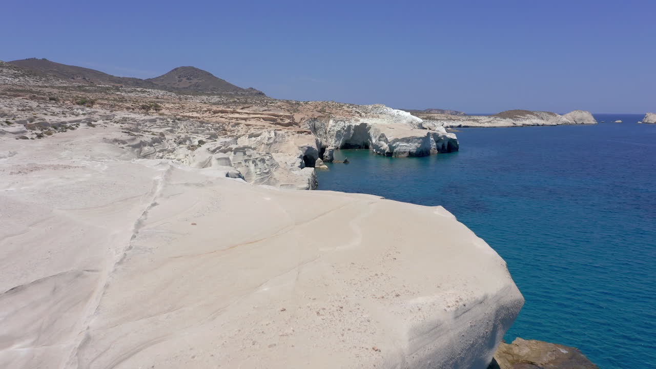 aéreo: foto panorámica lenta de drones de acantilados blancos en la costa de la playa de sarakiniko en la isla de milos