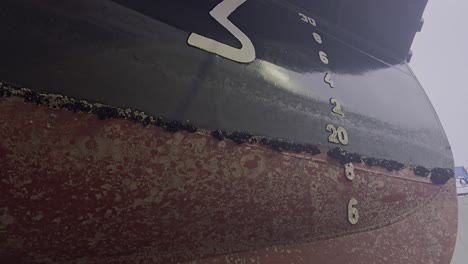 dirty ship hull near bow with marine growth and blue mussels along waterline. fouling reduces efficiency