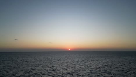 puesta de sol del océano índico en la playa de kusini al este de la isla de zanzíbar, tanzania áfrica, toma aérea de pedestal ascendente