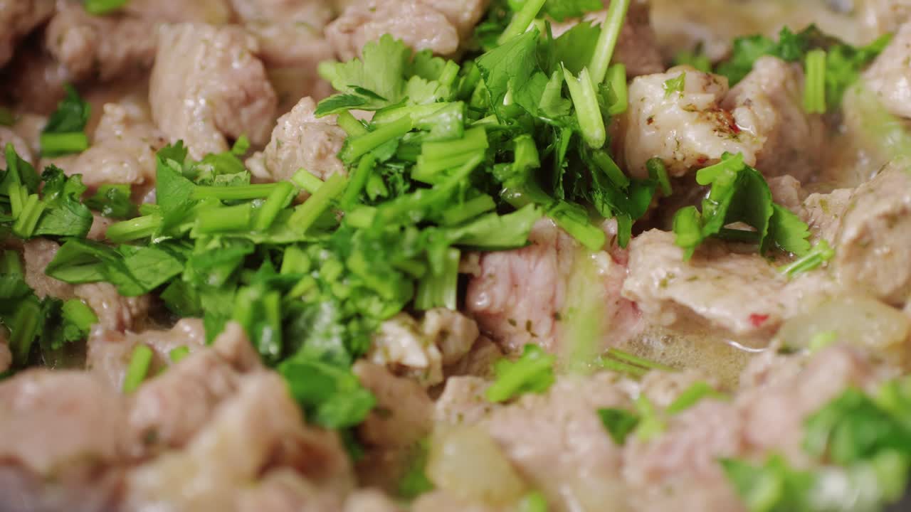 Chicken or pork stew with red and green pepper onion, and spices cooking in a frying pan. Traditional mexican cuisine, tacos preparation, ragout.