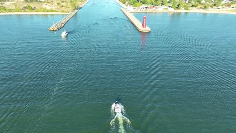 a personal boat slowing before entering the channel from lake michigan to muskegon lake